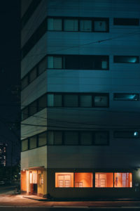 Night scene of an apartment building with the ground floor lit up, Osaka, Japan Night scene of an apartment building with the ground floor lit up, Osaka, Japan